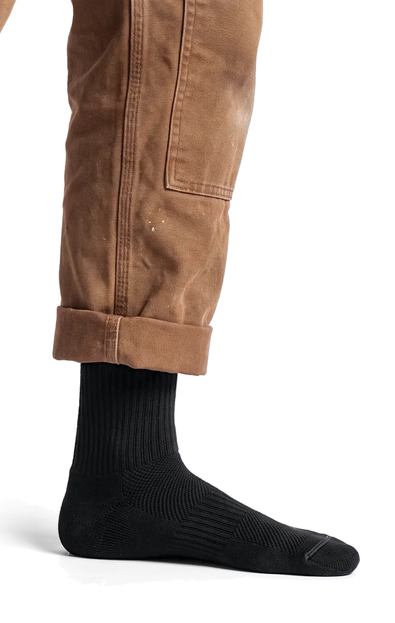 A black Merino Boot Sock under a rolled canvas work pant, side view