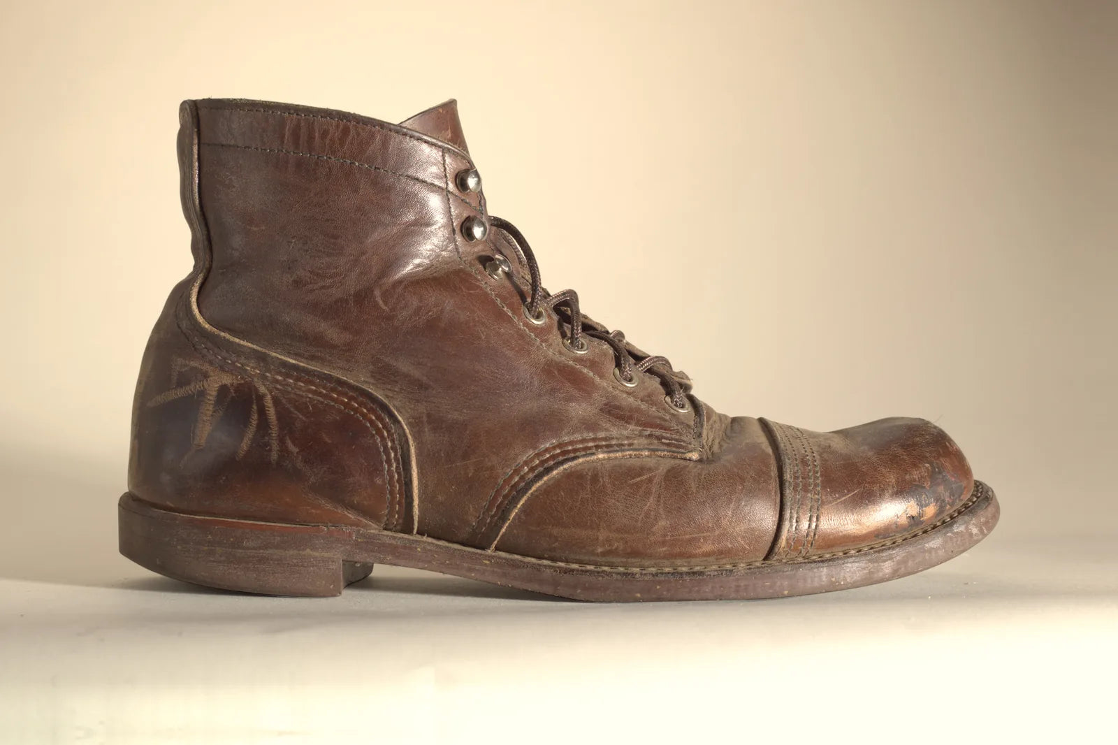 Inside of a brown Red Wing boot with heavy pale scratches on the heel and a scuffed toe, before Boot Wax