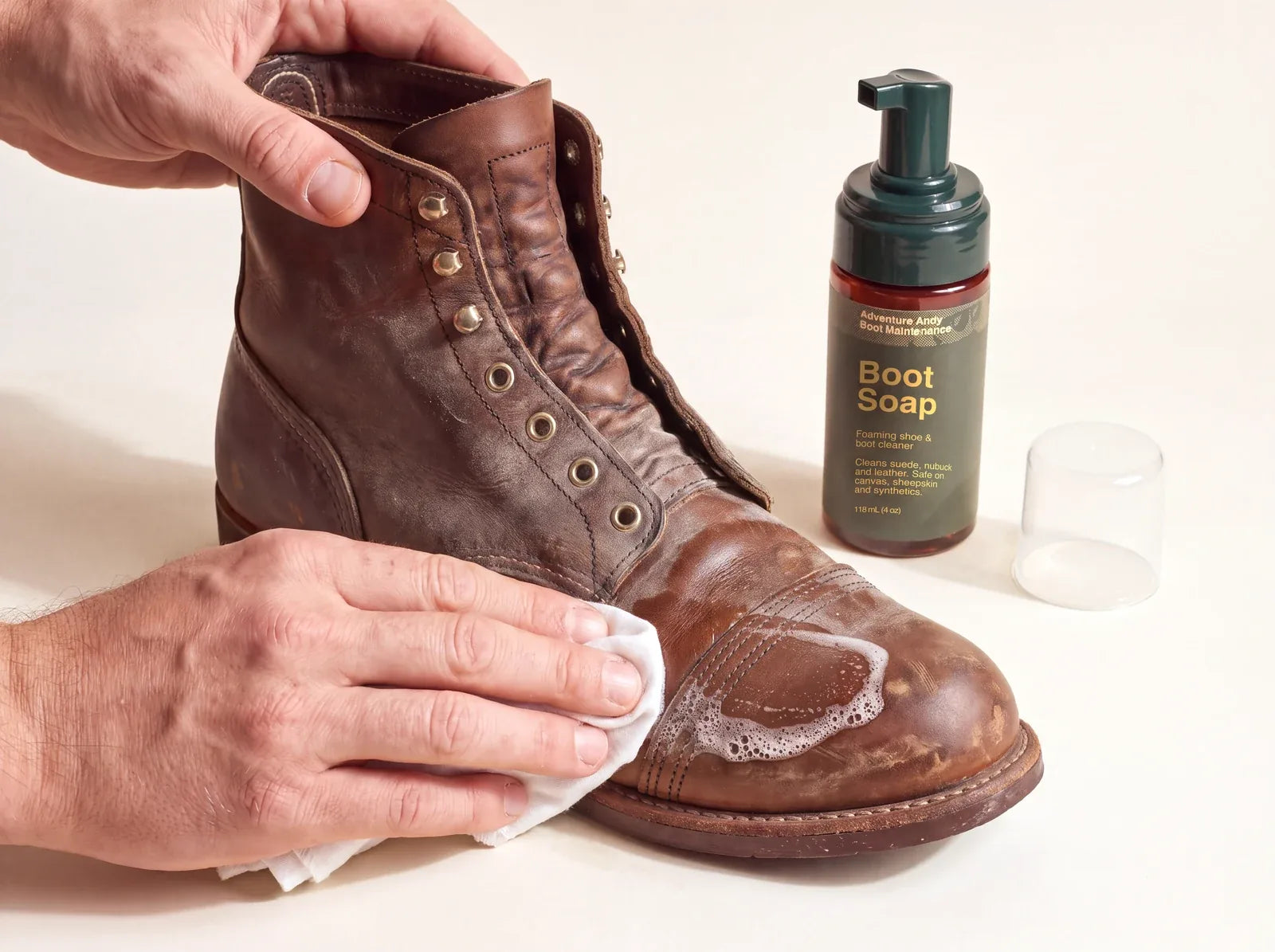 Wiping Boot Soap foam off a brown leather boot with a white cloth